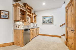 Kitchen featuring stainless steel fridge, sink, and light colored carpet