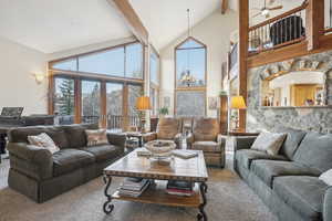 Living room with ceiling fan, french doors, beamed ceiling, high vaulted ceiling, and carpet