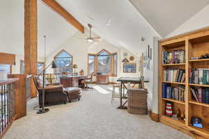 Living area with high vaulted ceiling, beamed ceiling, carpet, and ceiling fan