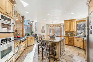 Kitchen with tasteful backsplash, appliances with stainless steel finishes, sink, a breakfast bar area, and a center island