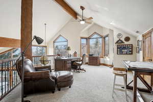 Office space featuring light carpet, high vaulted ceiling, and a healthy amount of sunlight