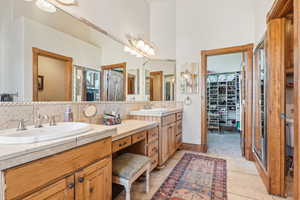 Bathroom with vanity, a towering ceiling, and tile patterned flooring