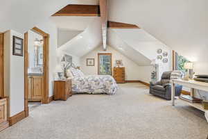 Bedroom with multiple windows, carpet, and vaulted ceiling with beams