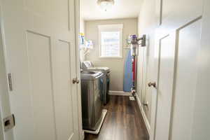 Washroom with washing machine and clothes dryer and dark hardwood / wood-style flooring