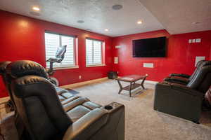 Carpeted cinema room featuring a textured ceiling