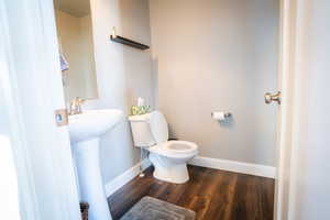 Bathroom featuring hardwood / wood-style flooring, toilet, and sink