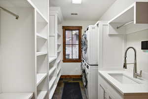 Clothes washing area with stacked washer / dryer and sink