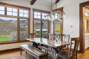 Dining space with light wood-type flooring and beamed ceiling