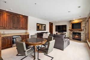 Dining space with a stone fireplace, wine cooler, and indoor bar