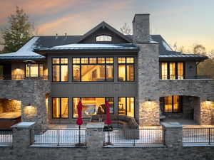 Back house at dusk with a patio and outdoor lounge area