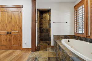 Bathroom featuring wood-type flooring and separate shower and tub