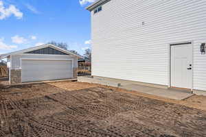 View of home's exterior with a detached garage and a basement entrance for potential ADU a