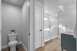 Master Bathroom with an enclosed shower, vanity, a textured ceiling, and toilet