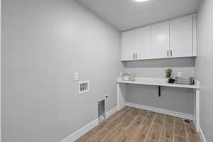 Laundry room with cabinets, hookup for a washing machine, and hookup for an electric dryer