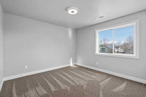 Bedroom 2 with carpet flooring and a textured ceiling