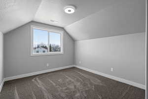 Bedroom 4 with lofted ceiling, carpet flooring, and a textured ceiling