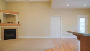 Living room with carpet, ceiling fan, and a gas insert fireplace