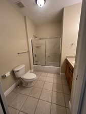 2nd Full bathroom with tile patterned flooring, shower / bath combination with glass door, toilet, and vanity