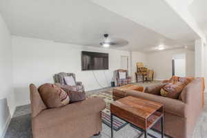 Carpeted living room with ceiling fan