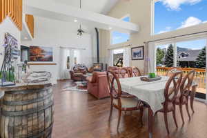 Dining space with a high ceiling, dark hardwood / wood-style flooring, a wood stove, and plenty of natural light