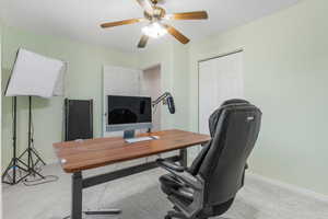 Office area with light carpet and ceiling fan