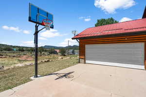 Garage with a mountain view and a yard