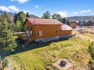 Rear view of property featuring a wooden deck and a yard