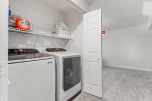 Laundry area featuring independent washer and dryer and light carpet