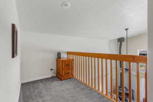 Hall with carpet and a textured ceiling