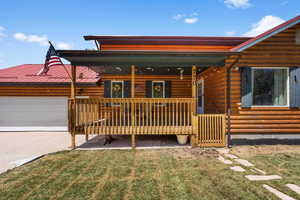 Log home featuring a garage and a front yard