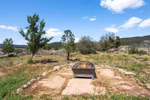 View of yard featuring a rural view, a fire pit, and a mountain view