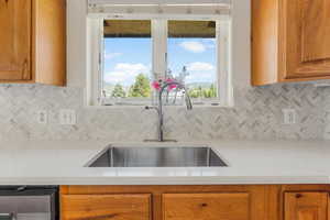 Kitchen with decorative backsplash, sink, and a healthy amount of sunlight