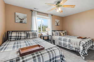 Carpeted bedroom featuring ceiling fan