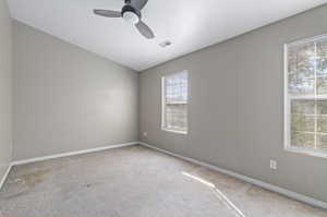 Carpeted empty room with ceiling fan