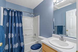 Full bathroom with shower / bath combo, vanity, and toilet