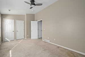 Unfurnished bedroom with vaulted ceiling, light carpet, and ceiling fan