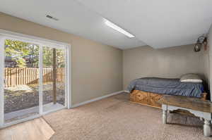 Bedroom with access to outside and wood-type flooring