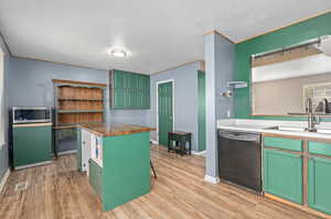 Kitchen featuring light hardwood / wood-style floors, sink, butcher block countertops, and dishwasher