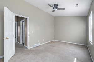 Carpeted empty room featuring ceiling fan