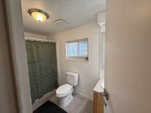 Bathroom featuring toilet, vanity, a textured ceiling, and hardwood / wood-style flooring