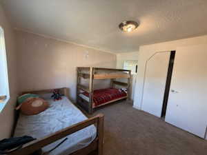 Bedroom featuring a textured ceiling and dark carpet