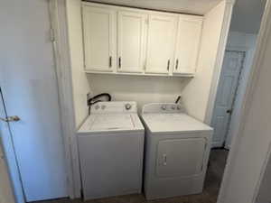 Laundry room featuring washing machine and dryer and cabinets