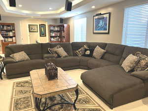 Living room featuring light carpet and a raised ceiling