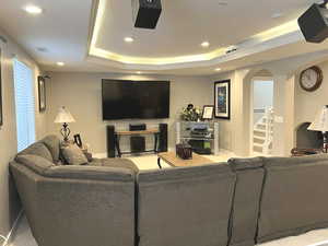 Living room featuring carpet flooring and a tray ceiling