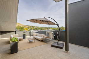 View of patio / terrace with an outdoor living space, a balcony, and a mountain view