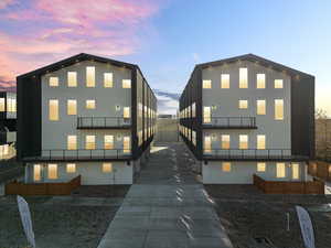 Back house at dusk featuring a balcony