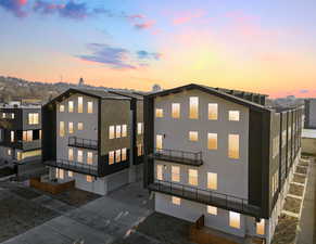 Rear view of property featuring a balcony and stucco siding