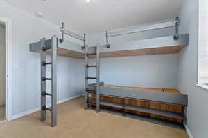 Bedroom featuring baseboards and light colored carpet