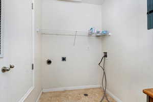 Laundry room with light tile patterned floors, hookup for a washing machine, laundry area, baseboards, and electric dryer hookup