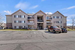 View of property featuring uncovered parking and stairway